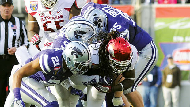 Arkansas Razorbacks running back Alex Collins is tackled by Kansas State Wildcats defensive back Kendall Adams during the first half at Liberty Bowl.