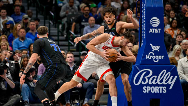 Rockets center Alperen Sengun looks to move to the basket past Dallas Mavericks guard Luka Doncic (77) and center Dereck Lively II (2) during the second quarter at the American Airlines Center.