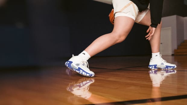 Hailey Van Lith models white and blue adidas basketball shoes.