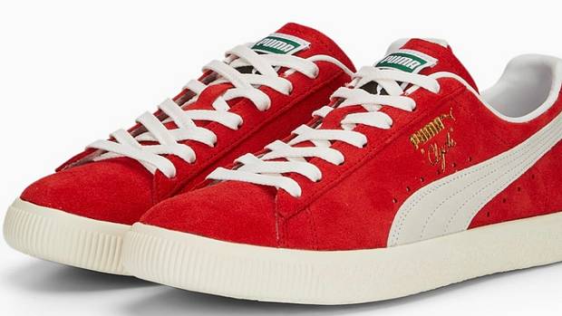 Side view of red and white Puma shoes.