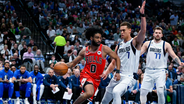 Apr 7, 2023; Dallas, Texas, USA; Chicago Bulls guard Coby White (0) dribbles the ball under the basket past Dallas Mavericks center Dwight Powell (7) and guard Luka Doncic (77) during the first quarter at the American Airlines Center.