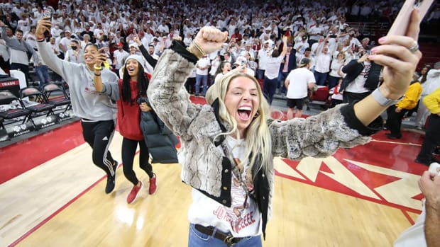 An Arkansas fan celebrates by running onto the floor at Bud Walton Arena during a white out game in 2022.
