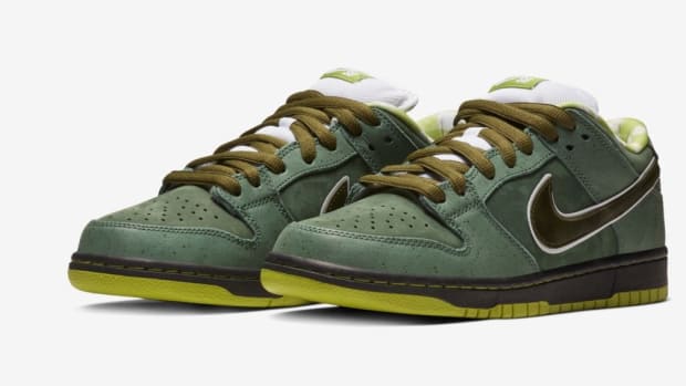 Side view of green and white Nike Dunk sneakers.
