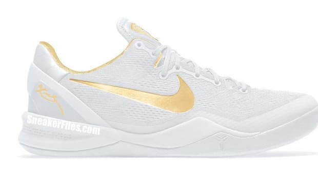 Side view of Kobe Bryant's white and gold Nike shoe.