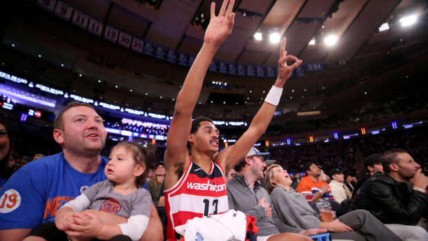 Washington Wizards guard Jordan Poole (13) reacts to a teammate's three point shot as he sits court side with fans during the third quarter against the New York Knicks at Madison Square Garden.