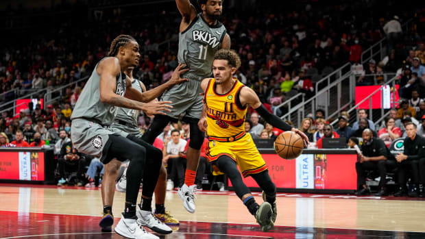 Apr 2, 2022; Atlanta, Georgia, USA; Atlanta Hawks guard Trae Young (11) dribbles past Brooklyn Nets guard Kyrie Irving (11) and forward Nic Claxton (33) during the second half at State Farm Arena.