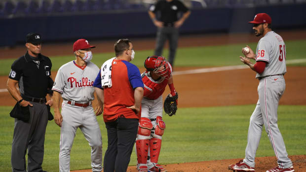 Zach Eflin is visited on the mound by medical trainer Paul Buchheit in Miami