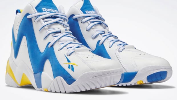 View of white, blue, and gold Reebok shoes.