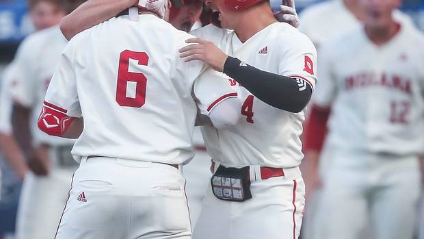 After Indiana's Peter Serruto (6) crosses home after hitting a three-run homer in the seventh, he gets a hug by teammates Josh Pyne, center, and Hunter Jessee as the Hoosiers went on to defeat Kentucky 5-3 Saturday night in the 2023 NCAA Regional at Kentucky Proud Park in Lexington.