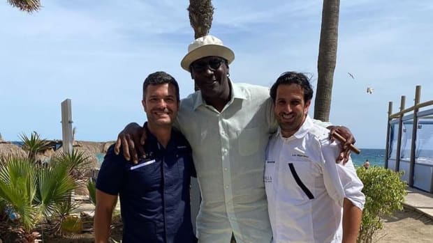 Michael Jordan poses for a picture with two fans.