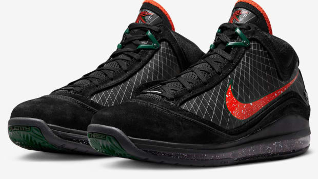 Side view of LeBron James' black, orange, and green Nike shoes.