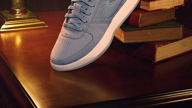 Devin Booker's grey Nike sneakers sit on top of books.