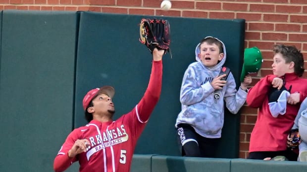 Razorbacks' Kendall Diggs leaps for a grab in front of fans in 6-3 win over Tennessee on Saturday night.