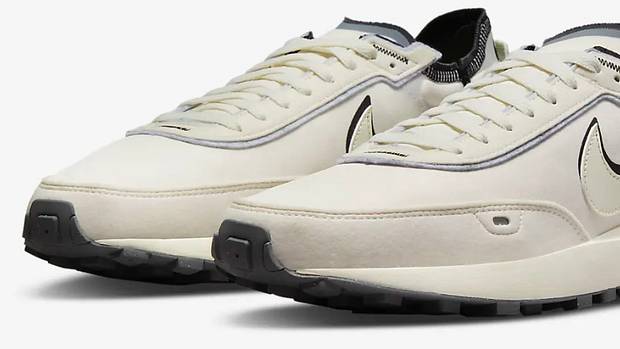 View of tan and black Nike shoes.