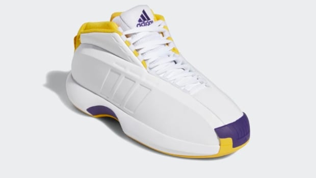 View of white, yellow, and purple adidas shoe.