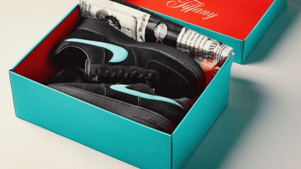 View of black Nike shoes in a teal box.