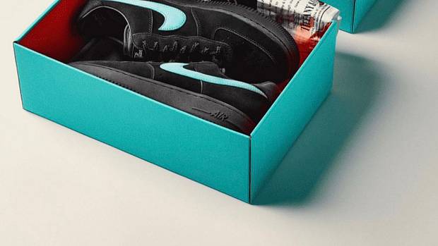 View of black Nike shoes in a teal box.