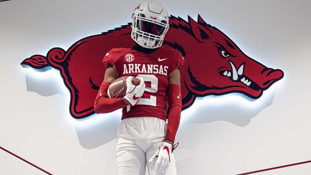 Arkansas recruiting target Selman Bridges, a Top 50 recruit out of Texas, poses with a football in an Arkansas uniform.