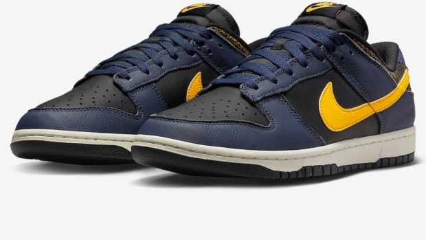 Side view of navy and black Nike Dunk Low sneakers.