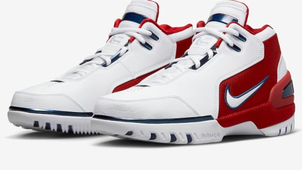 Side view of white and red Nike LeBron shoes.