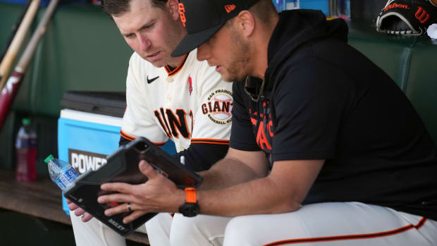 SF Giants starting pitcher Anthony DeSclafani (left) watches a tablet with pitching coach Andrew Bailey (right) during the fifth inning against the Pittsburgh Pirates at Oracle Park. (2023)