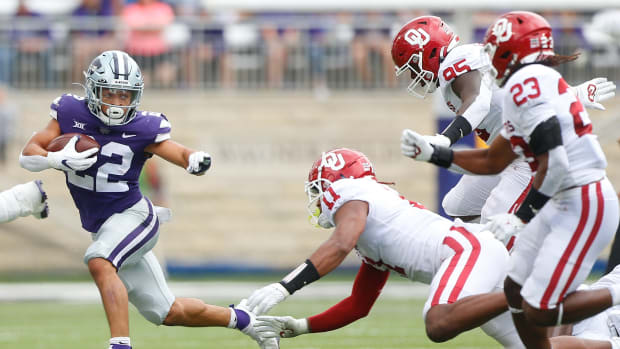 Kansas State sophomore running back Deuce Vaughn (22) escapes the grasp of Oklahoma defensivemen in the second quarter of Saturday's game at Bill Snyder Family Stadium.