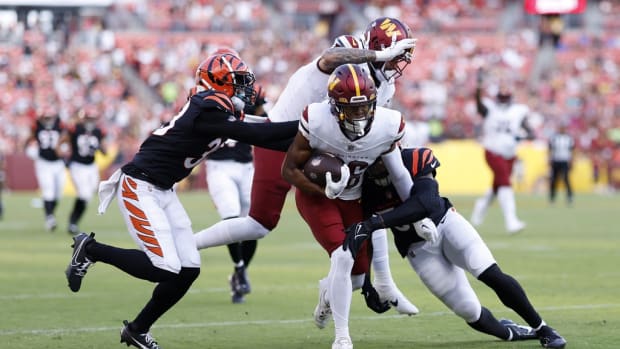Washington Commanders wide receiver Mitchell Tinsley (86) scores a touchdown as Cincinnati Bengals linebacker Markus Bailey (51) defends during the second quarter at FedExField.