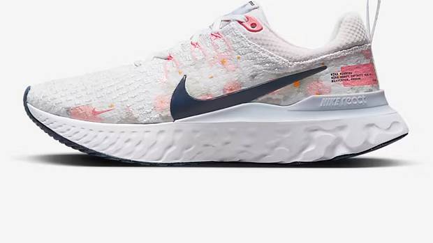 Side view of white and Navy Nike shoe.