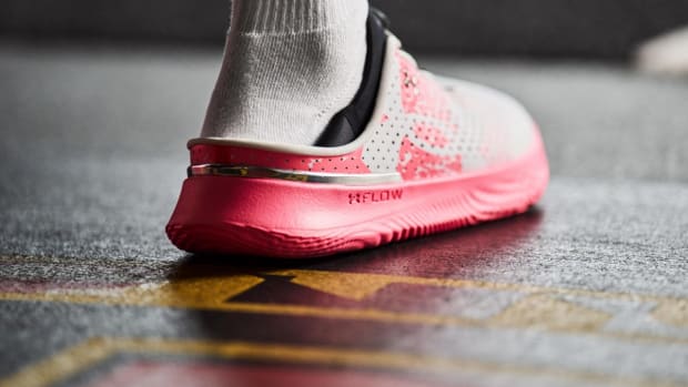 Rear view of pink and white Under Armour shoe.
