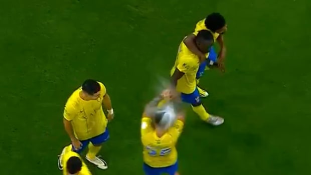 Cristiano Ronaldo pictured (left) standing next to Al Nassr teammate Otavio (center) when the midfielder was struck on the head by a full bottle of water thrown by an Al-Ahli fan during a Saudi Pro League game in March 2024