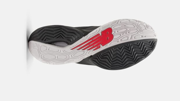 View of the white, black, and red outsole of a New Balance basketball shoe.