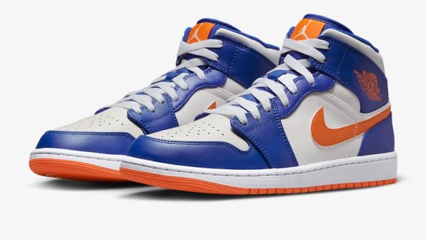 View of white, blue, and orange Air Jordan shoes.