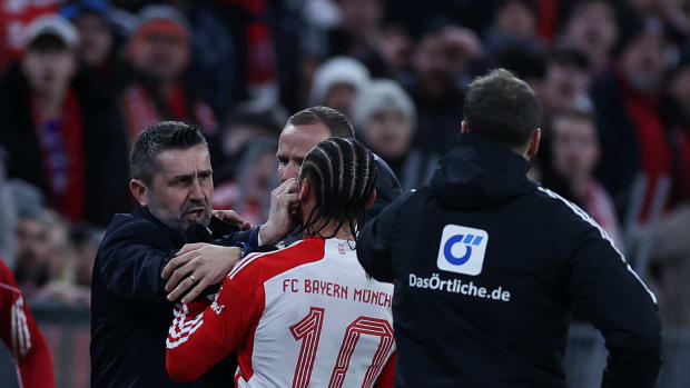 Union Berlin manager Nenad Bjelica pictured (left) pushing his right hand into the face of Bayern Munich winger Leroy Sane during a Bundesliga game in January 2024
