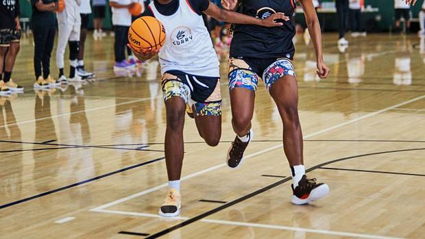 Two female basketball players compete at Stephen Curry's camp.