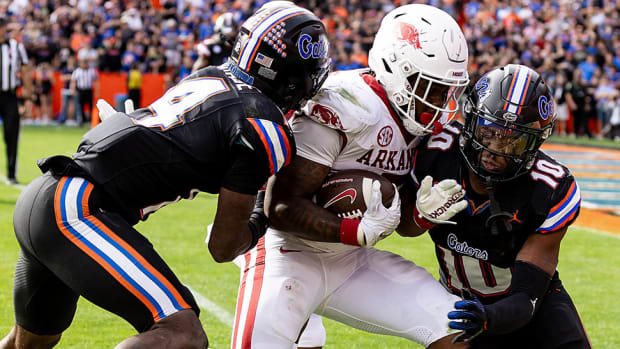 Florida Gators safeties Jordan Castell and Miguel Mitchell attempt to bring down Razorbacks running back Raheim Sanders during the second half of a 39-36 overtime loss to Arkansas in Gainesville.