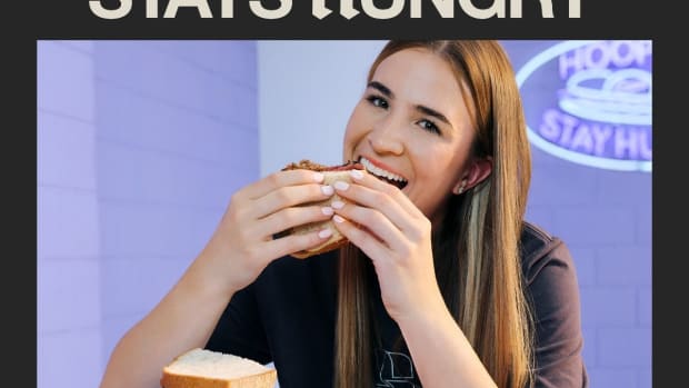 Sabrina Ionescu eats a sandwich in a promotional poster.