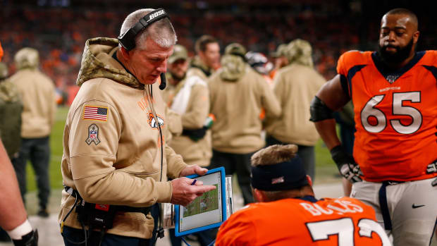 Denver Broncos offensive line coach Mike Munchak goes over a play with offensive tackle Garett Bolles (72) in the fourth quarter against the Cleveland Browns at Empower Field at Mile High.