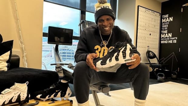 Deion Sanders poses with his black and white Nike sneakers.