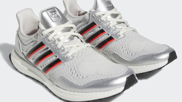 View of silver, black, and red adidas shoes.