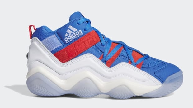 Side view of a red, white, and blue adidas sneaker.