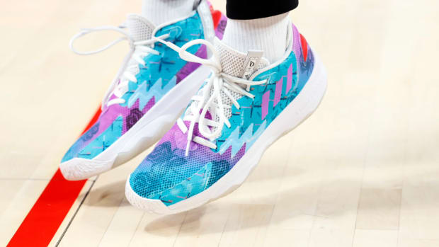 View of teal, purple, and white adidas shoes.