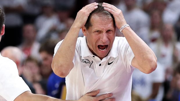 Arkansas coach Eric Musselman is held back during a frustrating moment against Duke.