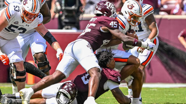 Texas A&M defensive lineman Walter Nolen loses his helmet while tackling an Auburn Tiger at Kyle Field.