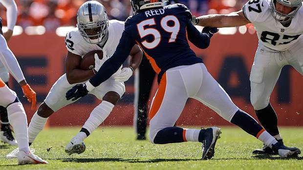 Las Vegas Raiders running back Kenyan Drake (23) runs the ball against Denver Broncos linebacker Malik Reed (59) in the first quarter at Empower Field at Mile High.