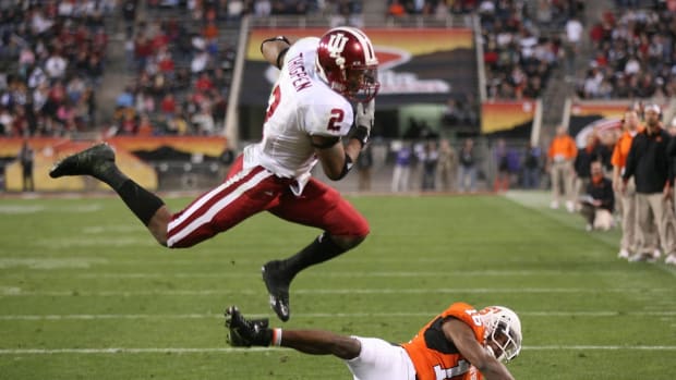 Indiana Hoosiers running back Marcus Thigpen leaps over Oklahoma State Cowboys defensive back Perrish Cox (16) during the second quarter