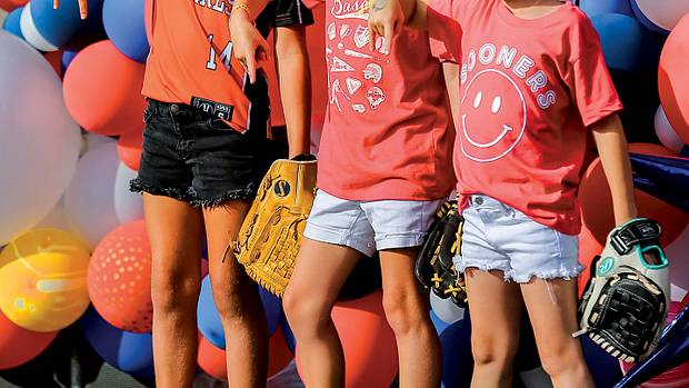 Young fans, Emersyn Edge, Parker Reimer and Emersyn Hensley wait to enter the stadium before the championship series softball game of the Women's College World Series between the University of Oklahoma Sooners (OU) and the Texas Longhorns at USA Softball Hall of Fame Stadium in Oklahoma City, on Wednesday, June 8