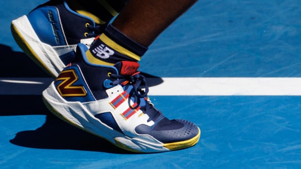 Coco Gauff's navy, white, and yellow New Balance tennis shoes.