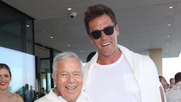 Tom Brady poses for a picture with Robert Kraft at a party.