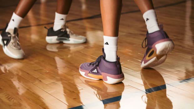 View of purple and orange adidas women's basketball shoes.