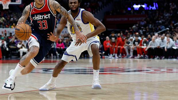 Washington Wizards forward Kyle Kuzma (33) drives against a Golden State Warriors defender.